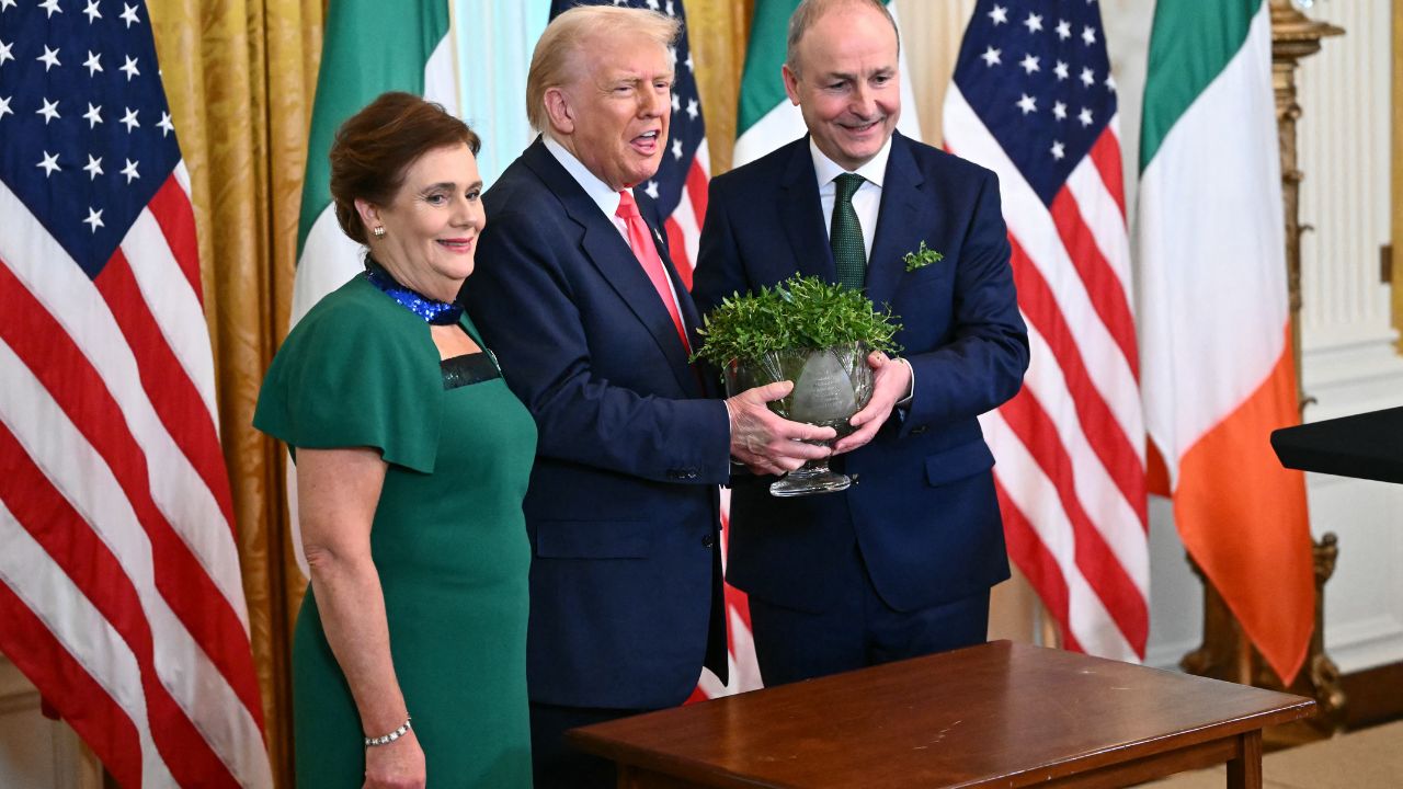 El presidente estadounidense Donald Trump y el primer ministro irlandés Michael Martin (der.) sostienen un cuenco de trébol junto a su esposa Mary O'Shea (izq.)
