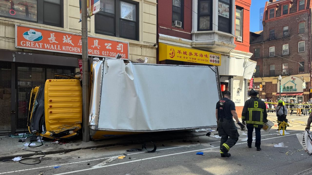 Un camión de la empresa Penske se estrelló contra postes y un edificio en Boston, EU; bomberos rescataron al chofer atrapado en la cabina.