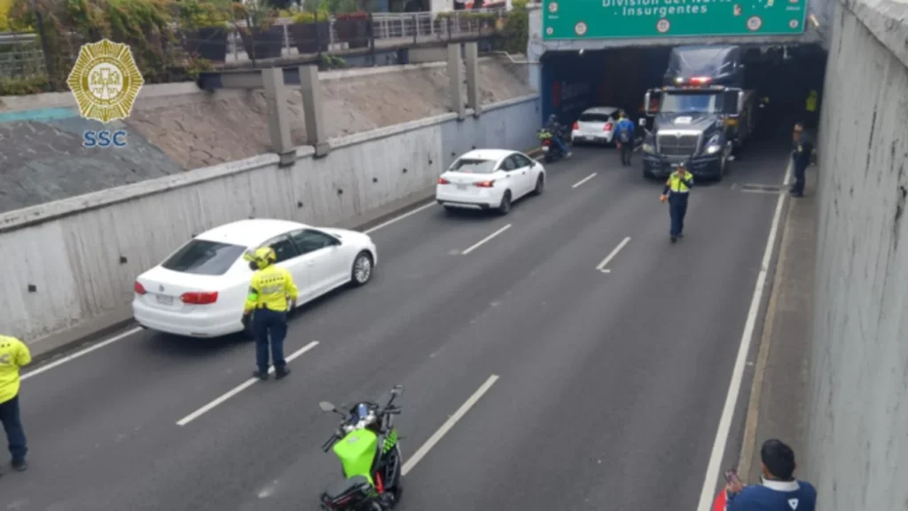 Tras algunos minutos de labores y cierre de carriles, personal de la SSC logró remover el tráiler atorado en el bajo puente de Viaducto.