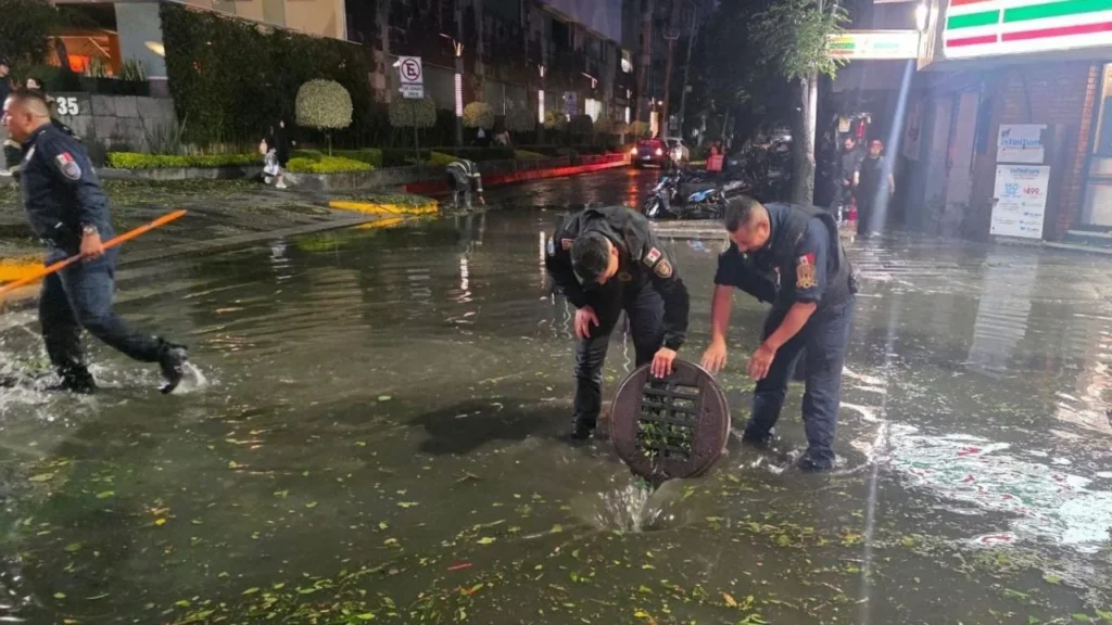  Policías de la SSC realizan el destape de coladeras y retiro de basura, para evitar encharcamientos en la avenida 
 Insurgentes Sur y la calle Yosemit, en la colonia Nápoles, gtras fuertes lluvias y granizo