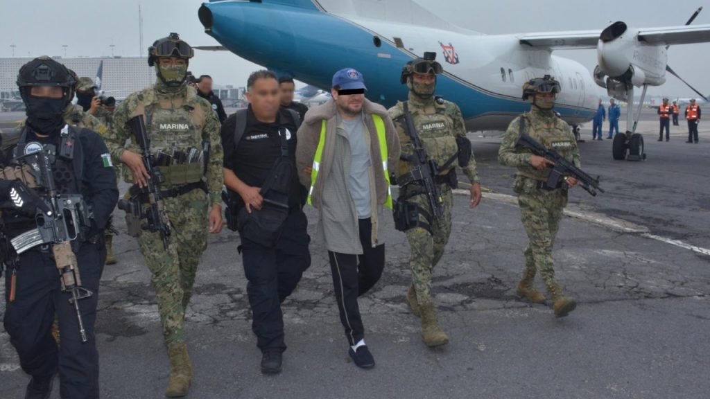 Traslado de Miguel Ángel “N”, alias “Capitán Sol”, custodiado por agentes de la Marina al descender de una aeronave militar en la pista de aterrizaje.